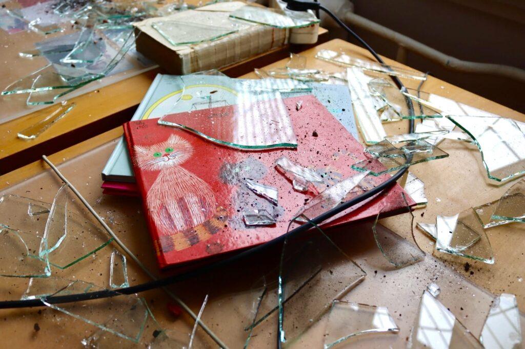 Пошкоджені дитячі книги серед битого скла після атаки на друкарню в Києві