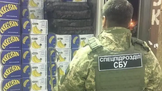 Офіцер СБУ біля коробок бананів та пакунків кокаїну