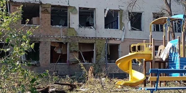 Зруйнована школа в Сумах після удару КАБами РФ з дитячим майданчиком на передньому плані